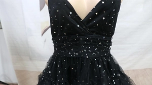 Detail of V-neck black mesh dress featuring shimmering silver star and moon patterns