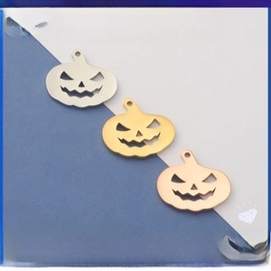 Macro detail of pumpkin hollow charms in silver, gold, and rose gold stainless steel