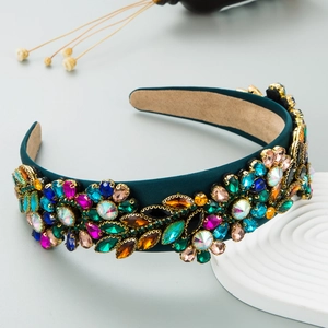 Macro detail of Baroque headband with colorful crystals on dark teal velvet fabric