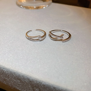 Détail macro de bagues croisées argentées avec zircons sertis et design ouvert ajustable
