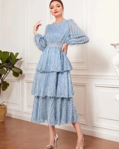 Detail of light blue tiered lace dress with fringe texture and matching waist belt