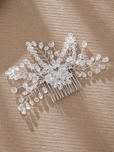 Macro detail of bridal hair comb with silver wire, crystal beads, and floral design