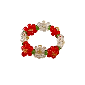 Handmade colorful beaded flower ring in red and white tones on a clean white background