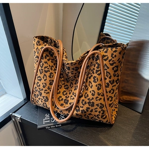 Fashionable leopard print tote bag with brown handles on a shelf in a modern interior