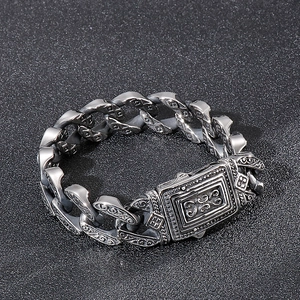 Close-up of retro punk style silver chain bracelet with engraved square safety clasp
