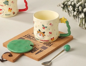 Detail of Christmas ceramic mug with green tree handle, matching lid and deer motif