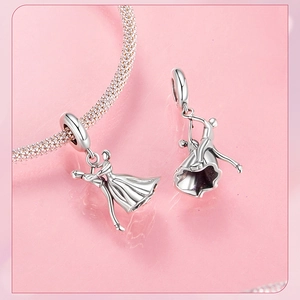 Macro shot of 925 silver dancing couple charm on a snake chain with romantic pink background