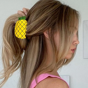 Cute yellow pineapple hair claw clip with green leaf detail on a model's ponytail