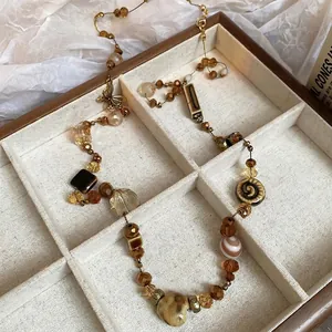 Vintage necklace with ceramic heart, crystal beads, and a bronze butterfly pendant