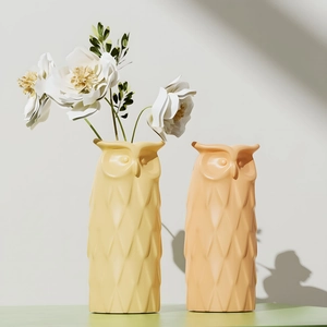 Detailed view of owl-shaped flower vases with geometric textures and floral arrangements