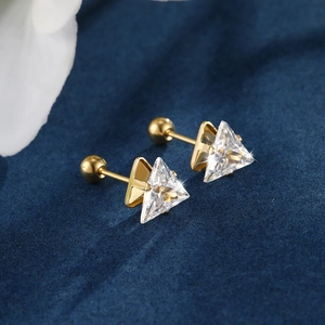 Detailed macro view of gold-plated triangle zircon stud with screw-back ball design