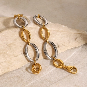 Detailed macro view of two-tone oval link chain bracelet with secure lobster clasp on stone