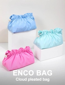 Dettaglio di pochette trucco con design a pieghe e cerniere con perle in tre colori