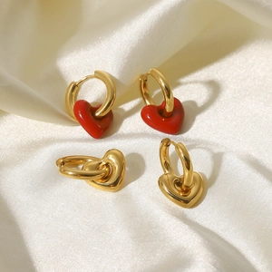 Détail de boucles d'oreilles créoles en acier doré 14K avec pendentifs en forme de cœur