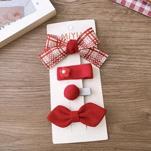 Detail of red 4-piece hair clip set with fabric bows and flowers on a display card