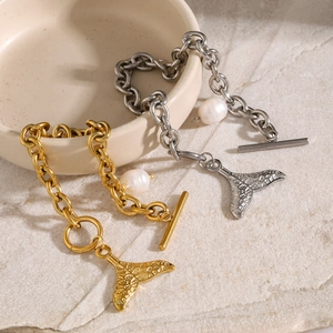 Detail of 18k gold chunky chain bracelet with fishtail charm and small white pearl