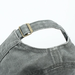 Detail of adjustable metal buckle and vintage washed cotton strap on the grey military cap
