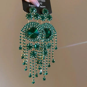 Detail of luxury emerald green rhinestone fringe earrings with geometric drop design
