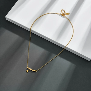 Elegant gold titanium steel bamboo pendant necklace displayed on a geometric background