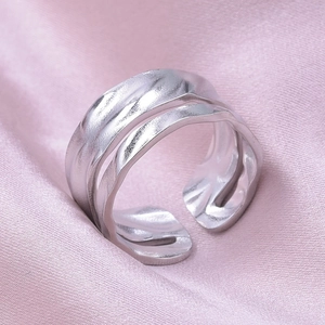 Macro detail of silver hammered texture on adjustable stainless steel ring with wavy edges
