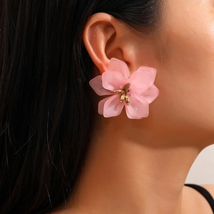 Pink frosted acrylic flower earrings with golden center shown on female model