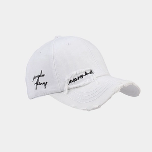 Detail view of white distressed baseball cap with simple things embroidery and frayed brim