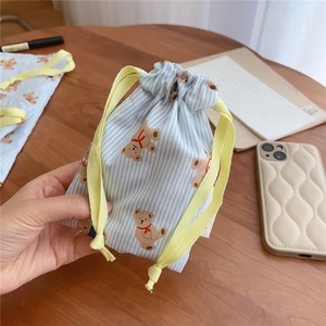 Close-up of blue striped cotton drawstring bag with cute bear print for travel storage