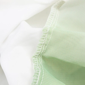 Detail of bohemian pleated skirt showing fine stitching and light green chiffon fabric texture