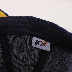 Detailed interior of dark blue denim baseball cap showing premium stitching and quality label