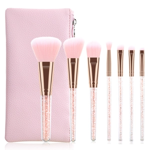 Detail of 7-piece pink makeup brush set with glitter handles and matching leather pouch