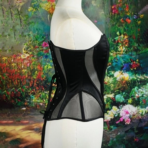 Black satin corset top with sheer mesh panels and boning structure on a mannequin