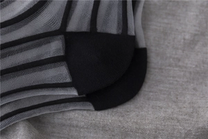 Macro shot of reinforced heel detail on breathable grey striped sheer mid-calf socks