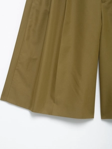 Detailed close-up of wide-leg cargo shorts hem in dark olive twill cotton fabric