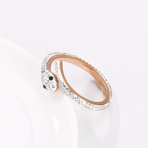 Sparkling rose gold snake ring with white crystals and green gemstone eyes for women