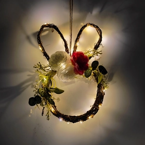 Close-up of lighted bunny grapevine wreath with pink flowers and warm LED lights