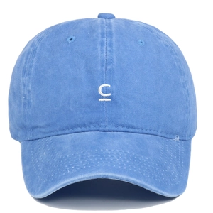 Détail de la broderie blanche lettre C sur la casquette en coton bleu délavé