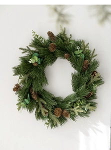 Detail of Christmas PE wreath with green pine needles, brown cones and eucalyptus leaves