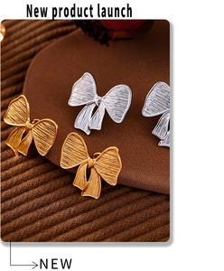 Macro view of gold and silver bow stud earrings with textured stainless steel finish
