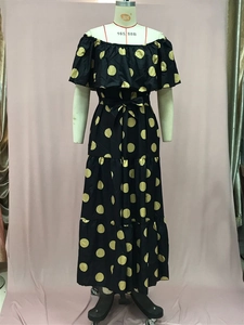 Details von schulterfreiem Maxikleid mit gelben Punkten und gestuftem Rüschensaum