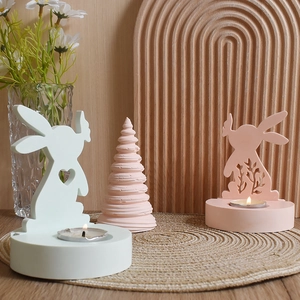 Detail von rosa und mintfarbenen Hasen-Kerzenhaltern mit Herz-Ausschnitten für Ostern