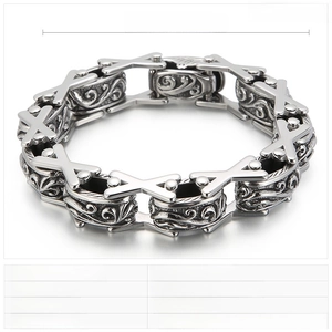 Detailed view of heavy vintage steel bracelet showing X-links and embossed floral cylinders