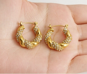 Close-up of twisted 18K gold-plated hoop earrings with micro-pave cubic zirconia crystals