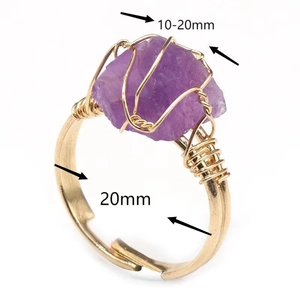 Détail d'une bague en fil doré faite main avec une pierre d'améthyste violette brute