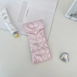 Macro view of heart-quilted pink PU leather storage pouch with soft padding and flap