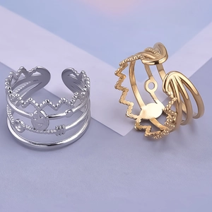 Detail view of gold and silver layered open rings with vintage hollow patterns