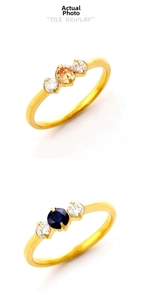 Close-up of vintage titanium steel rings with orange and blue center stones and clear gems
