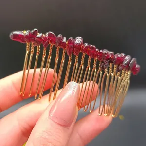 Dettaglio macro di pettine per capelli fatto a mano in filo dorato e pietre rosse