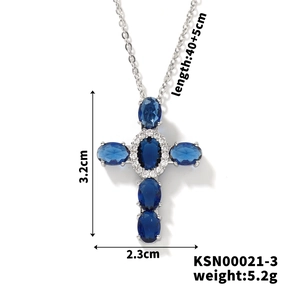 Detail view of silver cross pendant with blue oval stones and micro-pave zircon crystals