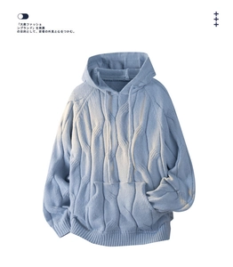 Detail of light blue cable knit hoodie with drawstring and soft textured fabric