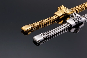 Macro view of men's wheat chain bracelet with a detailed lion head clasp in gold and silver